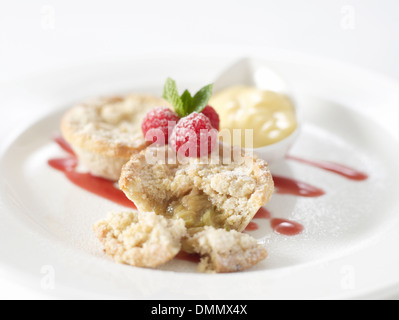 Apfel Rhabarber Torte Himbeeren Erdbeersauce Creme in einem Topf auf der Seite Stockfoto