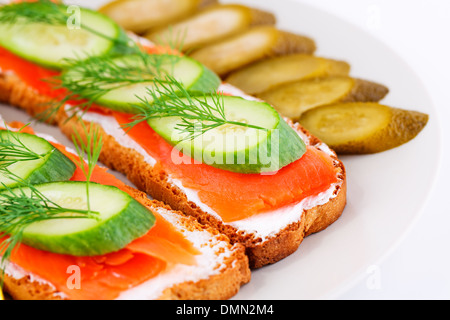 Lachs Sandwiches mit frische und eingelegte Gurken auf Platte Closeup Bild. Stockfoto