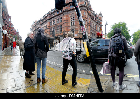 London, England, Vereinigtes Königreich. Menschen warten an einem Fußgängerüberweg Stockfoto