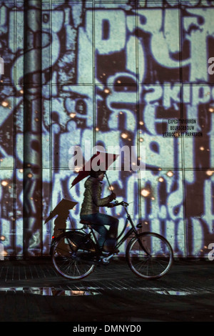 Niederlande, Eindhoven, Lichterfest GLOW 2013 genannt. Radfahrer mit Senz Sturm Regenschirm Stockfoto