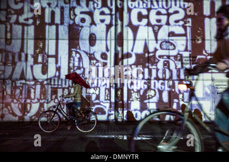 Niederlande, Eindhoven, Lichterfest GLOW 2013 genannt. Radfahrer mit Senz Sturm Regenschirm Stockfoto