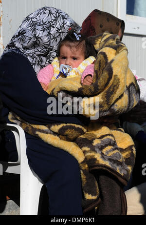 Kilis. 15. Dezember 2013. Eine Frau hält ihr Baby wartet auf Evakuierung in Kilis der Türkei am 15. Dezember 2013. Türkische Behörde sagte, die Zahl der Syrer in der Türkei Zuflucht hat bisher erreicht 600.000 und 4000 von ihnen waren gezwungen, in eine andere Grenzstadt Sanliurfa von temporären Flüchtling bewegen Lager, wegen der Kälte und Essen Engpässe. Bisher wurden 21 Flüchtlingslager in der Nähe von den Städten in der Nähe der türkisch-syrischen Grenze gegründet. © Lu Zhe/Xinhua/Alamy Live-Nachrichten Stockfoto