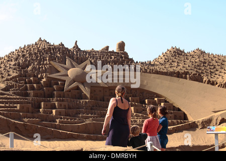 Eine Familie mit Blick auf eine Sandskulptur Krippe, die die Sterne leuchten über der Stadt Bethlehem zeigt. Stockfoto