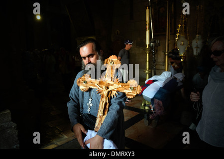 Ein christlicher Pilger tragen ein Kreuz aus dem Haupteingang der Kirche des Heiligen Grabes. Stockfoto