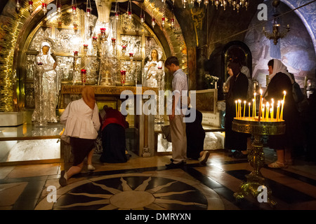 Christliche Pilger Warteschlange auf den Knien berühren wird vorbereitet und beten über die Felsen von Golgatha in der Kapelle der Kreuzigung. Stockfoto