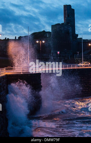 Aberystwyth Wales UK, brechen Dienstag, 17. Dezember 2013 Wellen über die Promenade im Schatten der Burg Aberystwyth bei Tagesanbruch. Sturm und Regen dürften im aus dem Westen des Vereinigten Königreichs fegen am Mittwoch 18 Dezember Photo Credit: Keith Morris/Alamy Live-Nachrichten Stockfoto