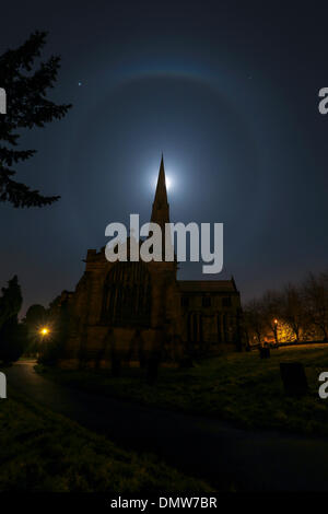 Ashbourne, Derbyshire, UK. 17. Dezember 2013.     In den frühen Morgenstunden von heute Morgen (Dienstag) hängt ein wahrhaft himmlischer Halo um den Mond über St. Oswald Kirche in Ashbourne, Derbyshire. Mit dieser eine vielleicht ähnlich einer riesigen festliche Christbaumkugel, sind Lichthöfe ein Zeichen der hohen dünnen Zirruswolken driften 20.000 Fuß oder mehr über unseren Köpfen.    Es gibt eine alte Wetter sagen: "Ring um den Mond bedeutet Regen bald". Gibt es Wahrheit zu diesem sagen, weil hohe Zirruswolken oft vor einem Sturm kommen.    Bildnachweis: Joanne Roberts/Alamy Live-Nachrichten Stockfoto