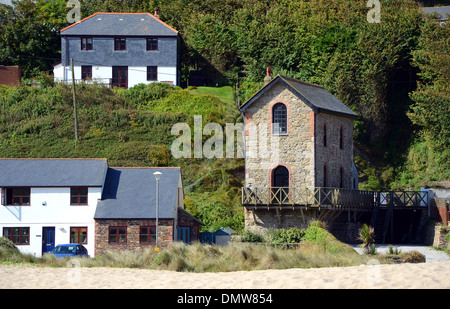 Eine renovierte Maschinenhaus aus einem ehemaligen Tin mine neben Neubauten am Porthtowan in Cornwall, Großbritannien sitzt Stockfoto