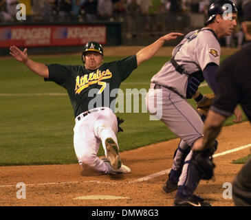 5. Juni 2001; Oakland, Kalifornien, USA; Jeremy Giambi breitet seine Flügel im 6. Inning erzielte der binden Flucht, 3-3 auf einem David Bell wirft Fehler während Johnny Damon Bunt versuchen. Mariners Catcher Dan Wilson erwartet den Wurf. Stockfoto