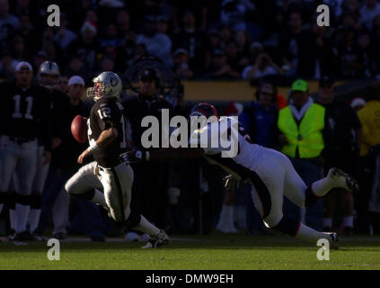 22. Dezember 2002; Oakland, Kalifornien, USA; Oakland Raiders Quarterback Rich Gannon, #12, wird ausgeführt, um zu vermeiden, entlassen von Denver Broncos' Monsanto Pope, #75, im 2. Quartal ihres Spiels auf Sonntag, 22. Dezember 2002 an Network Associates Coliseum in Oakland, Kalifornien Stockfoto