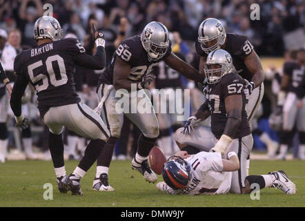 22. Dezember 2002; Oakland, Kalifornien, USA; Oakland Raiders Rod Coleman, #57 Säcke Denver Broncos Quarterback Steve Beuerlein, #11, als seine Teamkollegen (L-R) Eric Barton, #50, DeLawrence Grant, #99, und Regan Upshaw, #91, gratuliere ihm im 4. Quartal ihr Spiel auf Sonntag, 22. Dezember 2002 an Network Associates Coliseum in Oakland, Kalifornien Coleman entlassen Beuerlein am 4. unten Givi Stockfoto