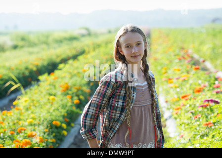 Im Sommer auf einem Bio-Bauernhof. Ein junges Mädchen in einem Feld von Blumen. Stockfoto