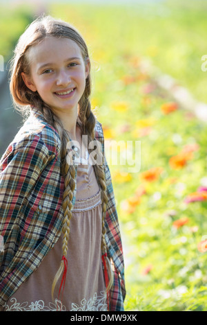 Im Sommer auf einem Bio-Bauernhof. Ein junges Mädchen in einem Feld von Blumen. Stockfoto