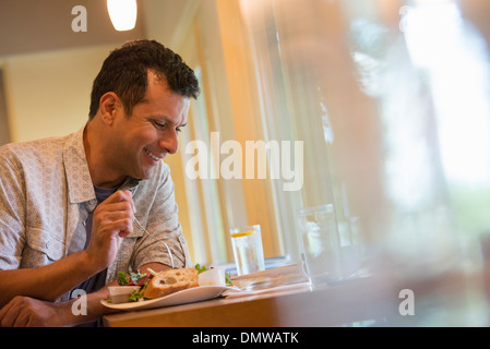 Ein Mann Essen einen Snack in einem Café. Stockfoto