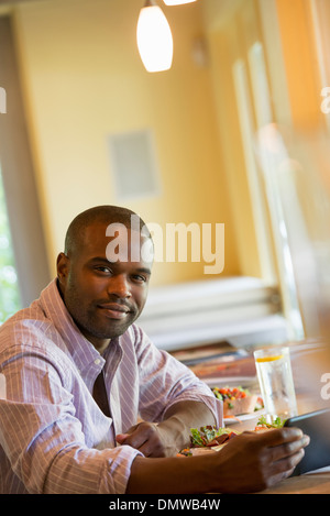Ein Mann in einem Café mit einem digitalen Tablet. Stockfoto