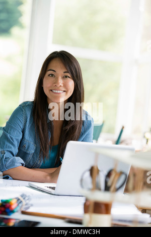 Eine Frau in einem Büro arbeitet an einem Laptopcomputer. Stockfoto