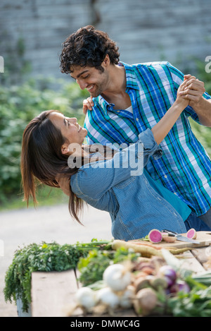 Ein paar umarmt und tanzen in einem Garten. Stockfoto