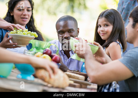 Erwachsene und Kinder an einem Tisch auf einer Party in einem Garten. Stockfoto