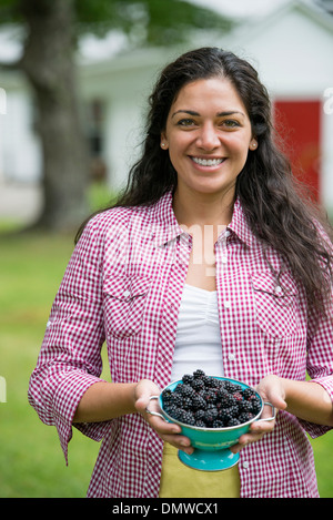 Eine Frau hält eine Schale mit frisch gepflückten Brombeeren. Stockfoto