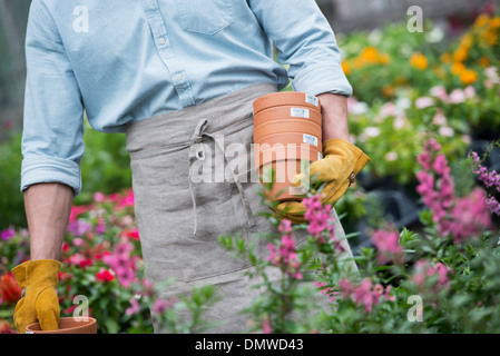 Ein Bio-Blumen-Gärtnerei. Ein Mann mit Blumentöpfen. Stockfoto