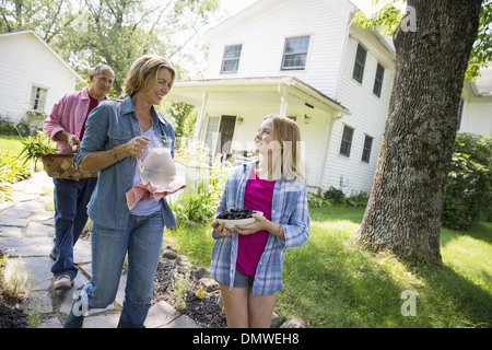 Ein Familien-Sommer-Garing auf einem Bauernhof. Zwei Erwachsene und ein junges Mädchen. Stockfoto