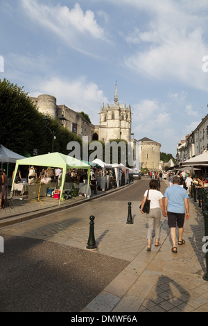 Amboise Sommer Abendmarkt, paar hand in hand spazieren Straße in der Nähe von Ständen mit Schloss im Hintergrund Stockfoto