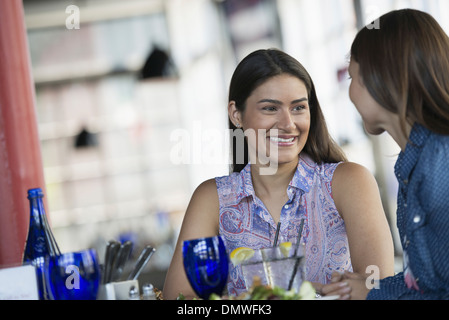 Zwei Frauen sitzen an einem Cafétisch mit einer Mahlzeit. Stockfoto