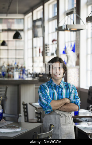 Ein Café-Interieur. Ein Kellner in ein kariertes Hemd. Stockfoto