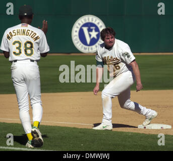 14. Oktober 2001; Oakland, Kalifornien, USA; Oakland As dritten Base Trainer Ron Washington klatscht wie Jason Giambi zum dritten Base nach einem Wild Pitch im dritten Inning von Spiel vier der American League Division Series gegen die New York Yankees an Network Associates Coliseum in Oakland, Kalifornien auf Sonntag, 14. Oktober 2001 bekommt. Stockfoto