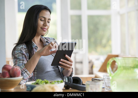 Eine Frau sitzt mit einem digitalen Tablet. Stockfoto