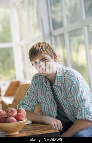 Ein kleiner Junge an einem Tisch sitzen. Stockfoto