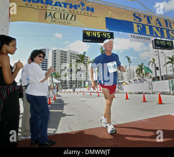 4. März 2001; West Palm Beach, FL, USA; Eusebio Cadogan, 69, der Juno Beach überquert die Ziellinie beim 2. jährlichen Marathon der Palmenstrände, wie Bürgermeister Lois Frankel ihm und anderen Läufern jubelt. Stockfoto