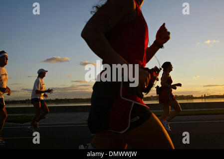 4. März 2001; West Palm Beach, FL, USA; Läufer in Richtung Meile 4 als die Sonne steigt im Osten von Flagler Laufwerk während des Marathons der Palmenstrände am 4. Dezember 2005. Stockfoto