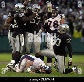 22. Dezember 2002; Oakland, Kalifornien, USA; Von links: Oakland Raiders Regan Upshaw (#91), feiern DeLawrence Grant (#99), Rod Coleman (#57) und Eric Barton (#50) nach der Entlassung von Denver Broncos Quarterback Steve Beuerlein, Boden, während ein vierter-Down-Spiel in den letzten Minuten des vierten Quartals ihres Spiels auf Sonntag, 22. Dezember 2002 an Network Associates Coliseum in Oakland, Kalifornien Stockfoto