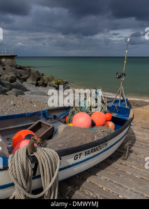 Kleines Fischerboot auf Kais Seite mit dunklen Gewitterwolken im Hintergrund Sheringham Norfolk England Stockfoto
