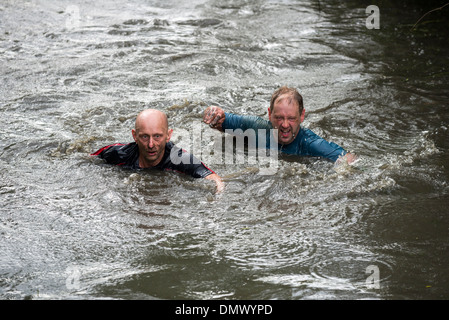 Wettbewerber Schwimmen im Wasser /pond bei Langstreckenrennen Tests Ausdauer und Fitness im Peak District Derbyshire England Stockfoto