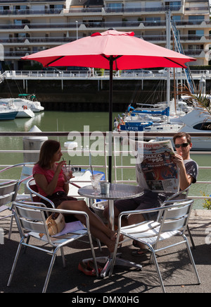 La Baule-Escoublac, gemeinhin als La Baule Mann und Frau genießen Eis an der Hafenpromenade lesen l ' Equipe Stockfoto