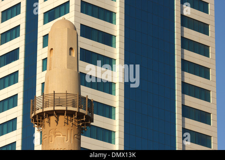 Minarett der Beit al-Quran gesehen gegen die Fassade eines modernen Bürogebäudes, Manama, Königreich von Bahrain Stockfoto