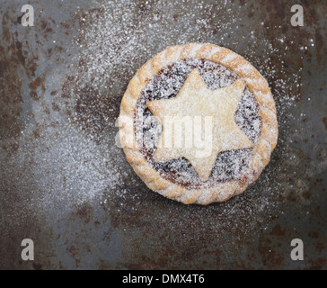 Einzelne hausgemachte Puderzucker bestäubt Mince Pie auf graue rustikale Metalloberfläche Stockfoto