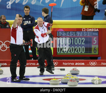 22. Februar 2006; Pinerolo, Italien; Die US-Männer Curling Team verlor ihr Halbfinale Spiel nach Kanada 11-5 Mittwoch Nacht in Pinerolo Palaghiaccio. Sie werden für die Bronze-Medaille am Freitag spielen. Foto zeigt: kanadische überspringen RUSS HOWARD, Zentrum und JAMIE KORAB signalisieren ihren Sieg, nachdem sie in der neunten Ende fünf Punkte. Die gelben Steinen dominiert das Haus. Im hinteren, US-ski Stockfoto