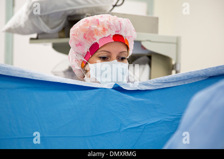Eine zertifizierte Krankenschwester Anästhesisten beobachtet, wie Chirurgen auf eine Frau mit Endometriumkarzinom eine Hysterektomie durchführen. Stockfoto