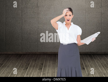 Zusammengesetztes Bild schockiert edel Geschäftsfrau hält Zeitung Stockfoto