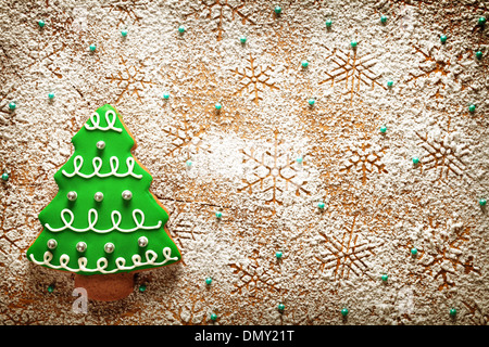 Weihnachten Hintergrund. Lebkuchen-Baum und Schneeflocken gemacht Puderzucker auf Holztisch. Ansicht von oben Stockfoto