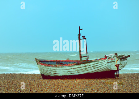 Verwitterte altes Fischerboot auf einem Kiesstrand mit der Nordsee im Hintergrund bei Alderburgh, UK Stockfoto