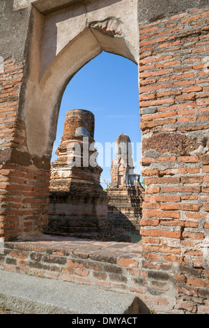 Die antiken Ruinen von Wat Phra Si Rattana Mahathat, Lopburi, Thailand.A Seite prang, wie aus einem Fenster im Haupttempel gesehen Stockfoto