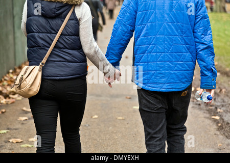 Ein paar Hand in Hand gehen im Hyde Park, London, England Stockfoto
