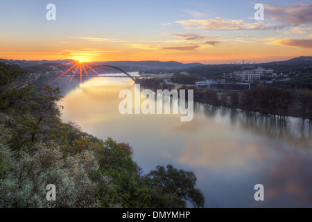 Die Sonne geht über den Colorado River und Pennybacker Brücke. In der Ferne ist die Skyline von Austin. Stockfoto