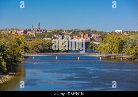 WASHINGTON, DC, USA - Fußgängerbrücke, Vordergrund, Roosevelt Island, rechts. Key Bridge, hinten und Healy Hall Türme. Stockfoto