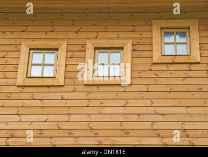 Wand von einem neuen Holzhaus mit drei Fenstern Stockfoto