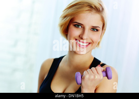 Porträt einer jungen Fit fröhlich Frau dabei Training mit Hantel Stockfoto